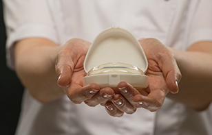 Female doctor orthodontist holding a mouth guard