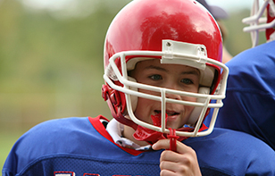 a junior football player with a helmet and mouth guard for protection