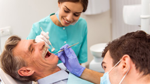 A Denturist and Nurse Checking Denture Implants on a Senior Man