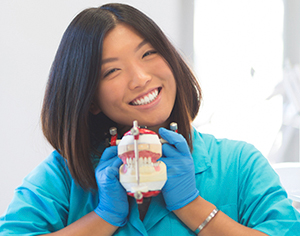 Happy Asian Student Holding Dentures