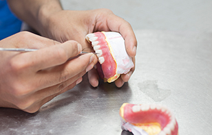 Dental Technician Fixing Dentures