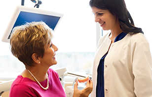 Dentist and Senior Patient with Dentures Smiling